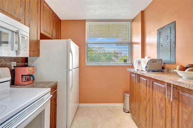 7080 Environ Blvd Unit 223, Lauderhill, FL 33319 - kitchen featuring white appliances, brown cabinetry, baseboards, light countertops, and light marble finish flooring