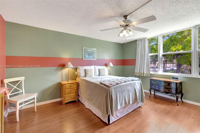 7080 Environ Blvd Unit 223, Lauderhill, FL 33319 - bedroom with wood finished floors, a textured ceiling, baseboards, ceiling fan, and ensuite bath