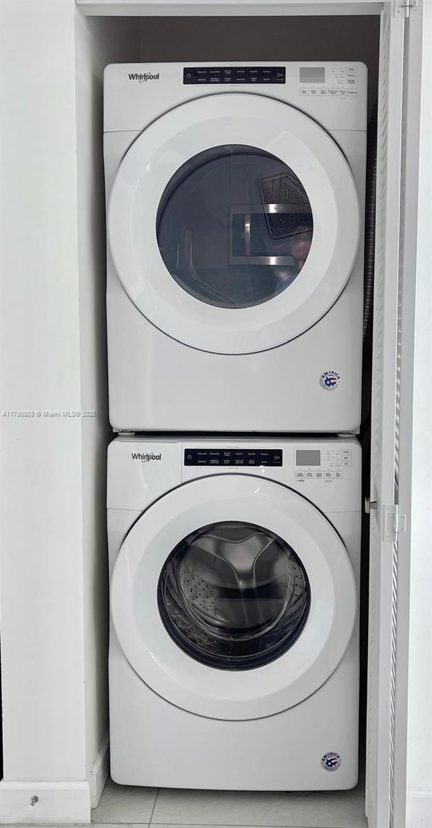 clothes washing area with stacked washer / dryer