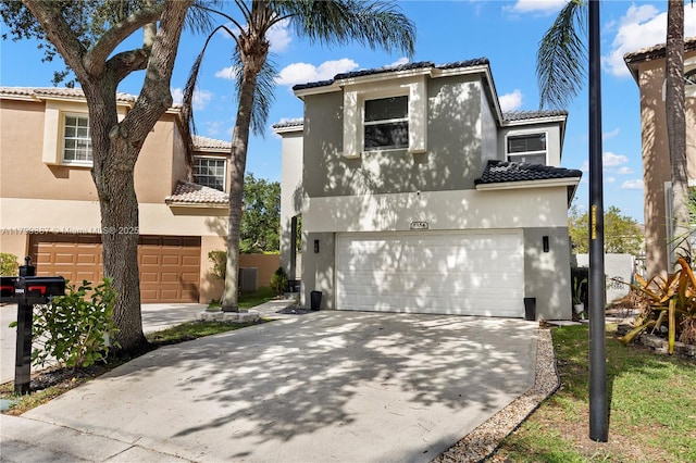 mediterranean / spanish-style home with a garage, stucco siding, concrete driveway, and a tile roof