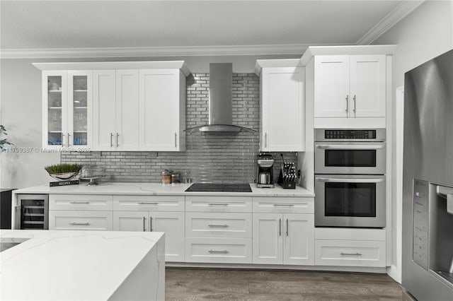 kitchen featuring wall chimney exhaust hood, appliances with stainless steel finishes, beverage cooler, decorative backsplash, and ornamental molding