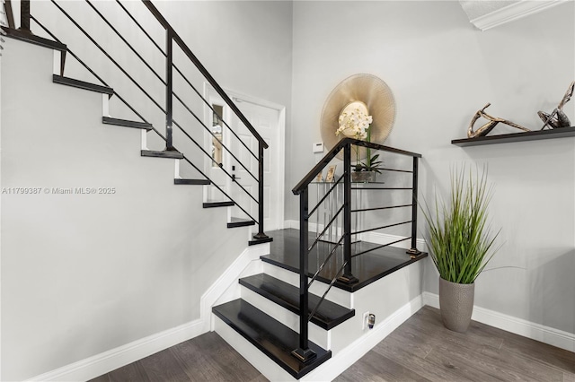 stairway with wood finished floors and baseboards