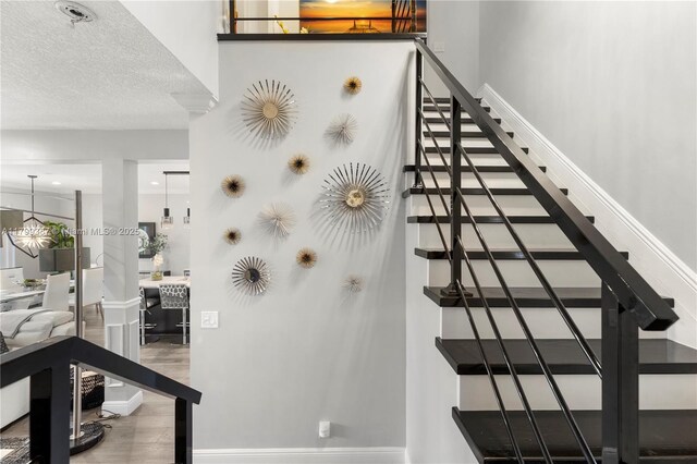 staircase featuring wood finished floors and baseboards