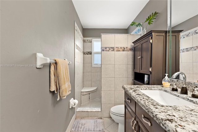 full bathroom with toilet, tiled shower, tile patterned flooring, and vanity