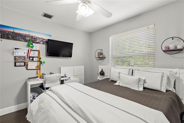 bedroom with wood finished floors, a ceiling fan, and baseboards