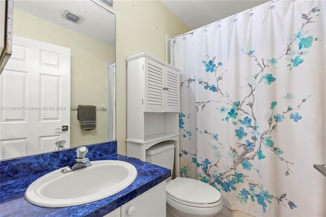 bathroom with toilet, vanity, and curtained shower