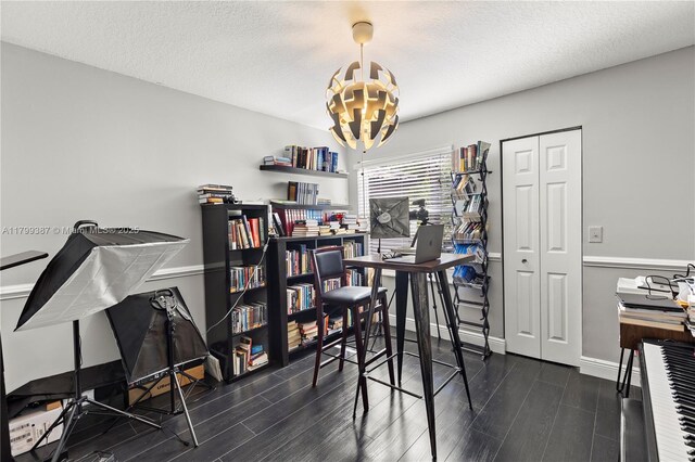 dining area with a chandelier, dark wood-style flooring, baseboards, and a textured ceiling