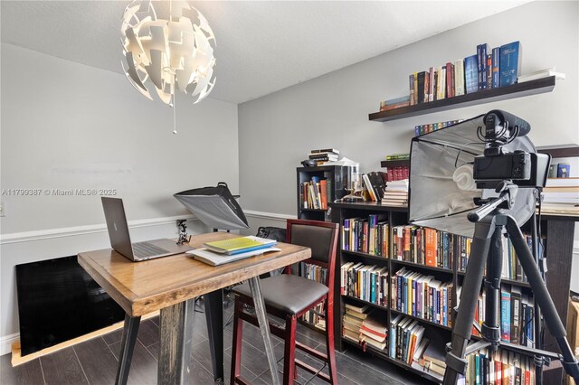 home office with a chandelier, wood finished floors, and baseboards