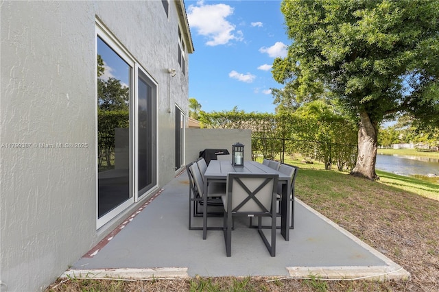 view of patio with outdoor dining space and a water view