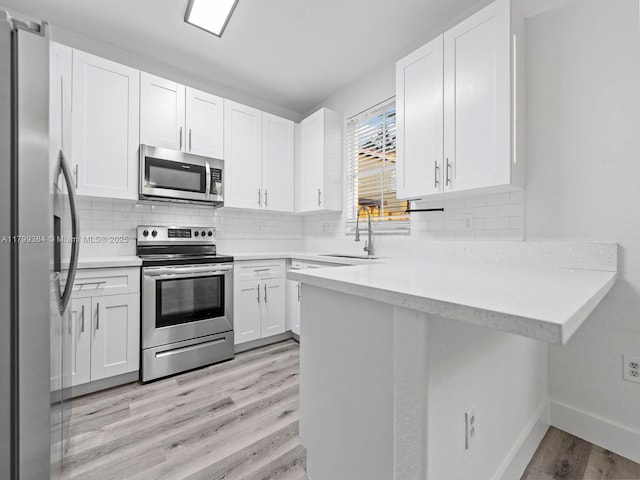 2482 SE 14th Ct, Homestead, FL 33035 - kitchen featuring stainless steel appliances, a sink, light wood-type flooring, and tasteful backsplash