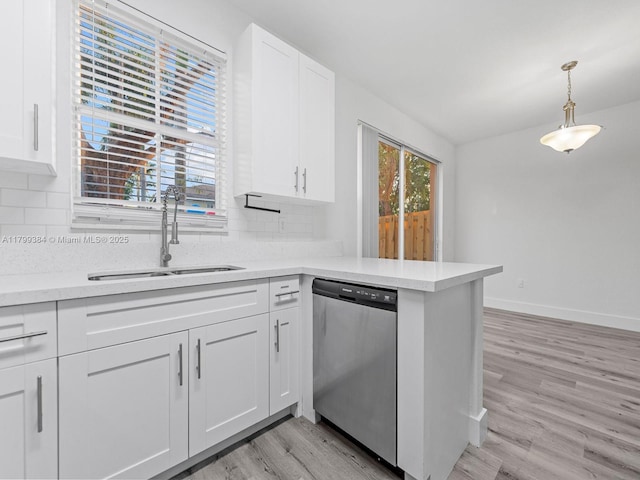2482 SE 14th Ct, Homestead, FL 33035 - kitchen featuring stainless steel dishwasher, a sink, backsplash, light countertops, and light wood finished floors