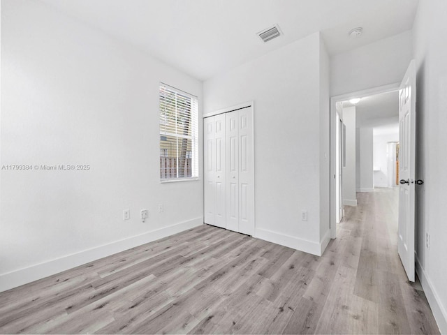 2482 SE 14th Ct, Homestead, FL 33035 - unfurnished bedroom featuring light wood-style floors, a closet, and baseboards