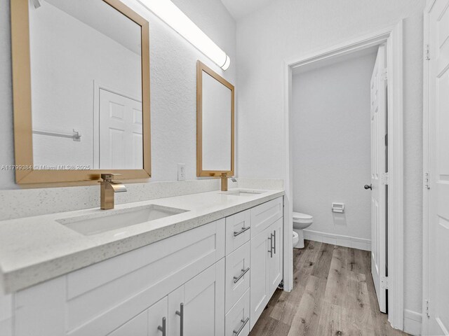 2482 SE 14th Ct, Homestead, FL 33035 - bathroom with toilet, double vanity, and wood finished floors