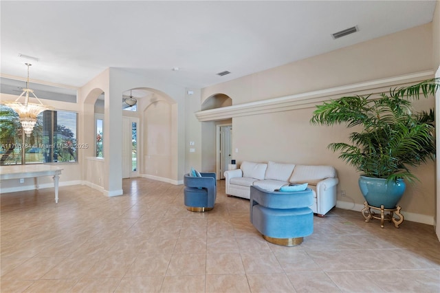 5514 NW W Lundy Cir, Port St Lucie, FL 34986 - living area featuring arched walkways, light tile patterned floors, a chandelier, and baseboards