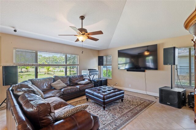 5514 NW W Lundy Cir, Port St Lucie, FL 34986 - living room featuring light tile patterned floors, lofted ceiling, a ceiling fan, healthy amount of natural light, and a wood stove