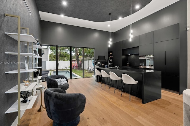 400 NW 49th St, Miami, FL 33127 - bar featuring a high ceiling, stainless steel oven, light wood finished floors, recessed lighting, and pendant lighting