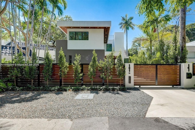 1780 Chucunantah Rd, Miami, FL 33133 - back of property featuring stucco siding, a fenced front yard, and a gate