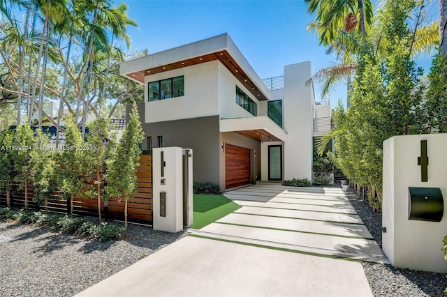 1780 Chucunantah Rd, Miami, FL 33133 - contemporary home featuring stucco siding, a balcony, driveway, and fence