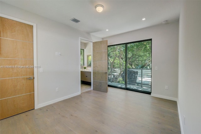1780 Chucunantah Rd, Miami, FL 33133 - unfurnished bedroom with wood finished floors, baseboards, access to outside, connected bathroom, and recessed lighting