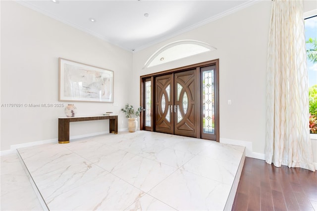 foyer featuring ornamental molding, baseboards, and wood finished floors