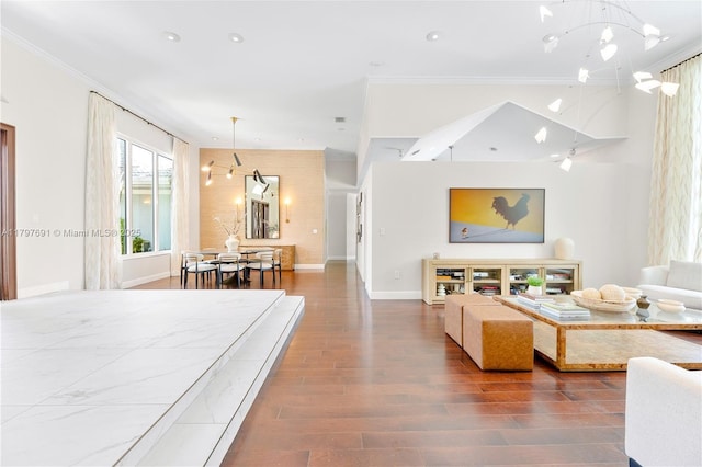 living area with ornamental molding, wood finished floors, a chandelier, baseboards, and recessed lighting