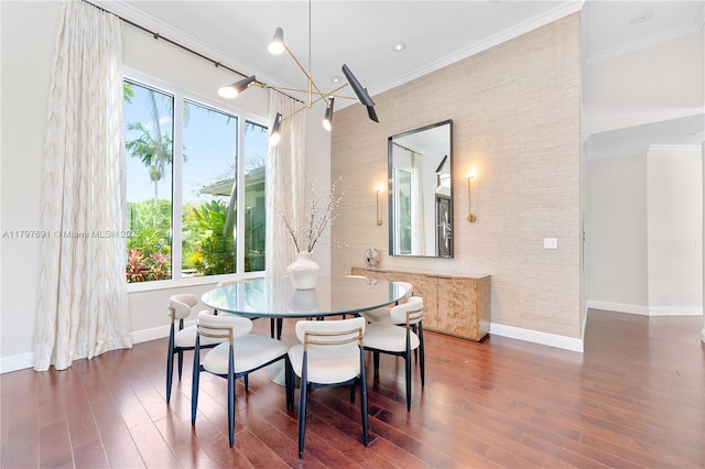 dining area featuring baseboards, wood finished floors, crown molding, and a chandelier