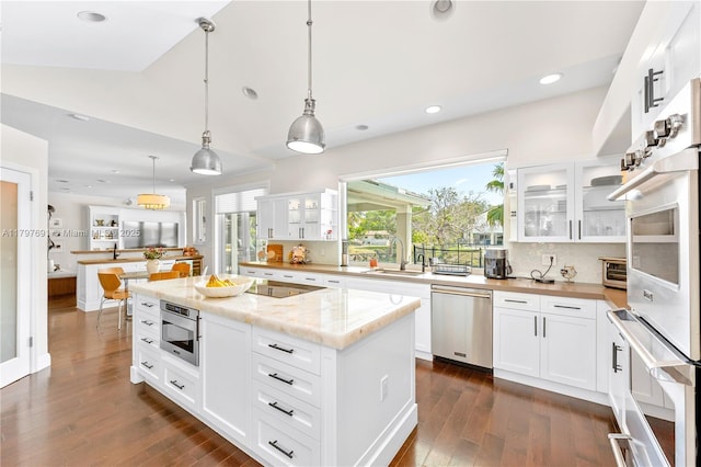 kitchen featuring dishwasher, a sink, built in microwave, dark wood-style flooring, and a center island