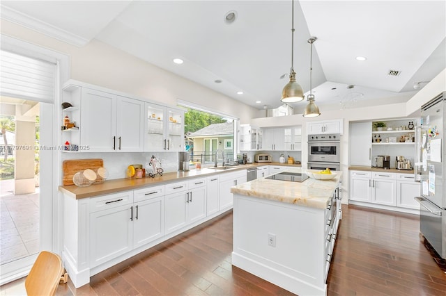 kitchen featuring open shelves, stainless steel appliances, a sink, a kitchen island, and white cabinetry