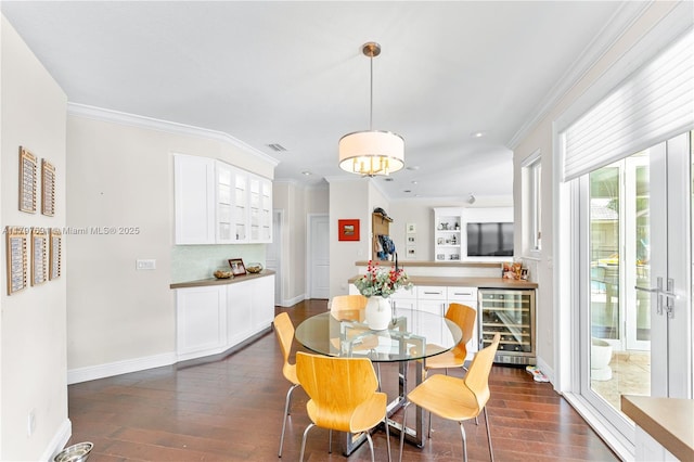 dining room with beverage cooler, dark wood-style floors, ornamental molding, baseboards, and recessed lighting
