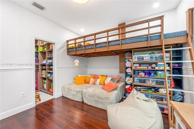 bedroom featuring wood finished floors, wainscoting, a spacious closet, and a closet