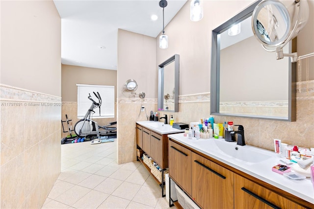 full bath with tile walls, a wainscoted wall, tile patterned floors, and two vanities