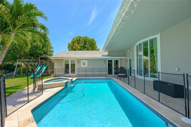 view of pool with french doors, fence, a patio, a playground, and a pool with connected hot tub