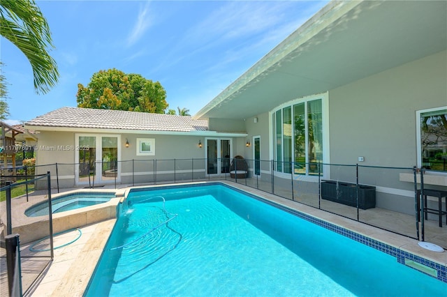 view of pool featuring french doors, a pool with connected hot tub, a patio area, and fence