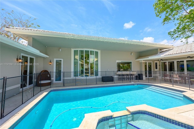 view of pool featuring a patio area, ceiling fan, and a pool with connected hot tub