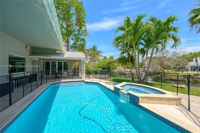 view of pool featuring a patio, fence, a pool with connected hot tub, and a water view