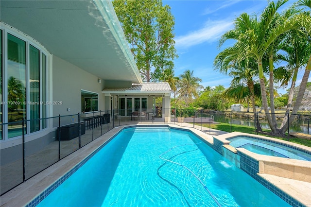 view of swimming pool featuring fence, a patio area, and a pool with connected hot tub