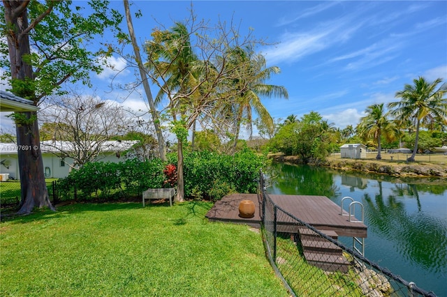 dock area with a yard and a water view