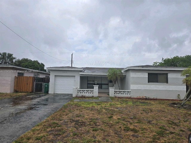 7917 Juniper St, Miramar, FL 33023 - single story home featuring asphalt driveway, an attached garage, a porch, fence, and stucco siding