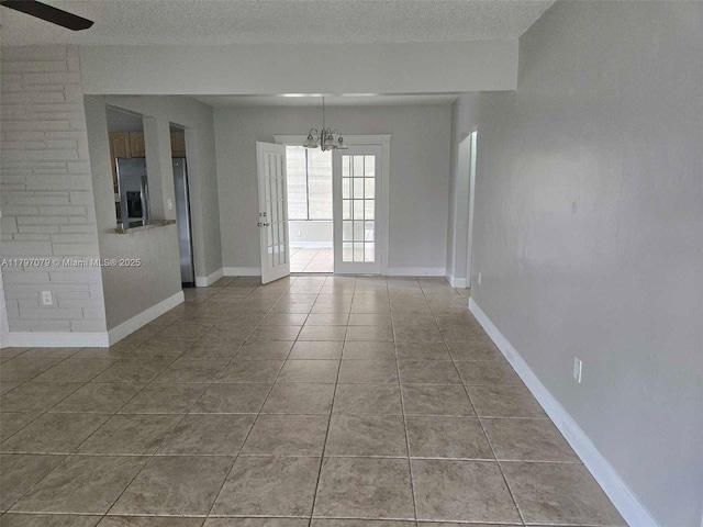 7917 Juniper St, Miramar, FL 33023 - tiled spare room featuring a textured ceiling, a chandelier, and baseboards