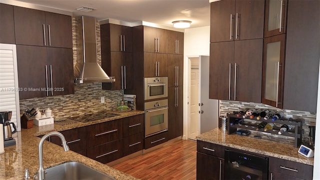 1374 NW 159th Ave, Pembroke Pines, FL 33028 - kitchen featuring wall chimney range hood, black electric stovetop, wine cooler, tasteful backsplash, and light stone countertops
