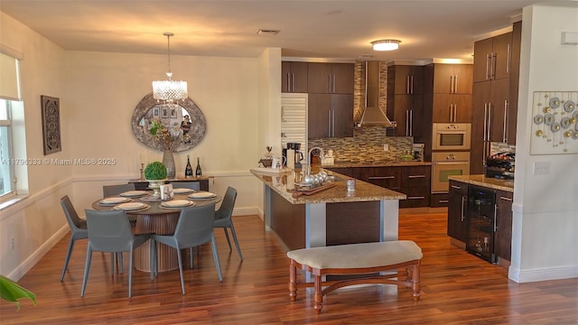 1374 NW 159th Ave, Pembroke Pines, FL 33028 - kitchen featuring wall chimney exhaust hood, beverage cooler, a peninsula, tasteful backsplash, and dark wood-type flooring
