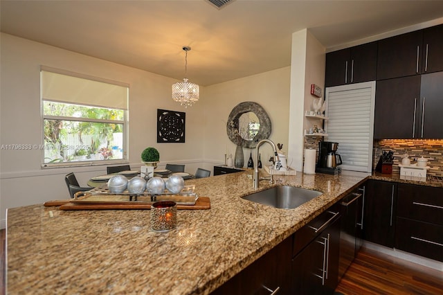 1374 NW 159th Ave, Pembroke Pines, FL 33028 - kitchen with a sink, dark wood finished floors, light stone countertops, backsplash, and a chandelier