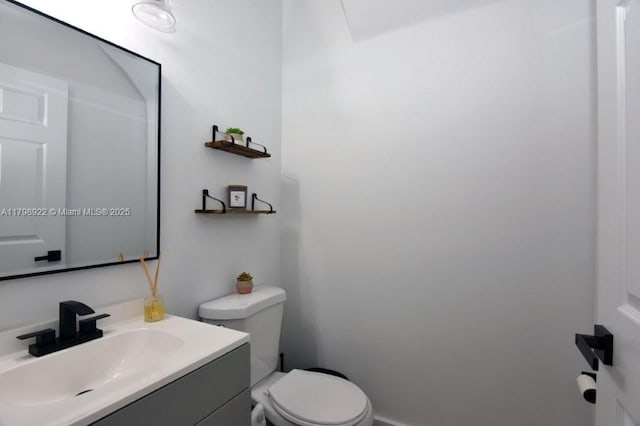 half bathroom featuring toilet and vanity