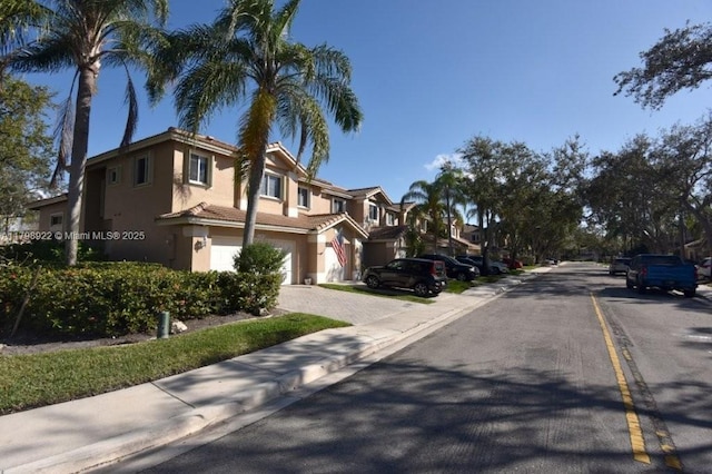 view of asphalt road featuring sidewalks, curbs, and a residential view