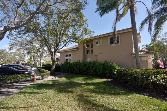 15899 SW 12th St, Pembroke Pines, FL 33027 - view of side of home with stucco siding, a yard, and a tile roof