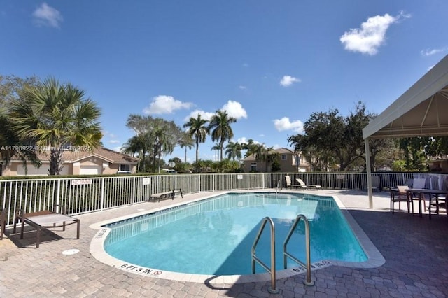 community pool featuring a patio and fence
