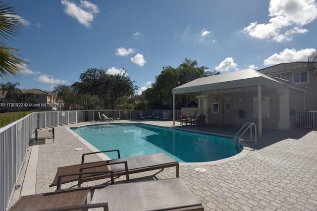community pool featuring a patio and fence
