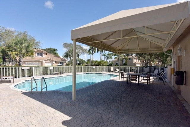 community pool with fence, a patio, and a gazebo