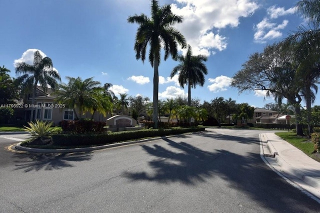 view of asphalt road featuring curbs and sidewalks