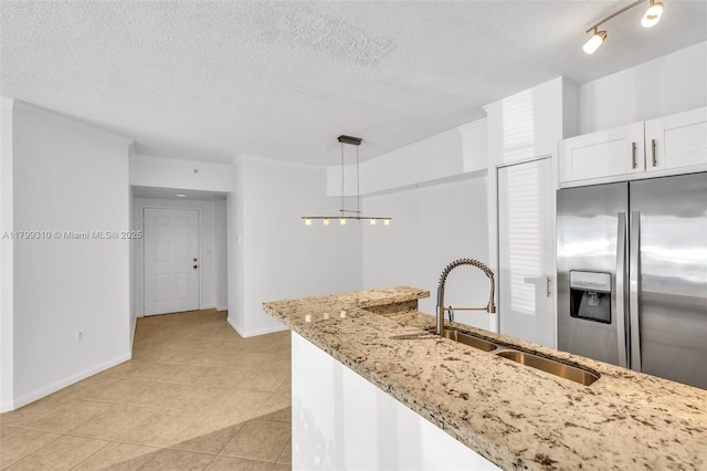 11643 W Atlantic Blvd Unit 1101, Coral Springs, FL 33071 - kitchen with stainless steel fridge, a textured ceiling, a sink, light stone countertops, and white cabinets